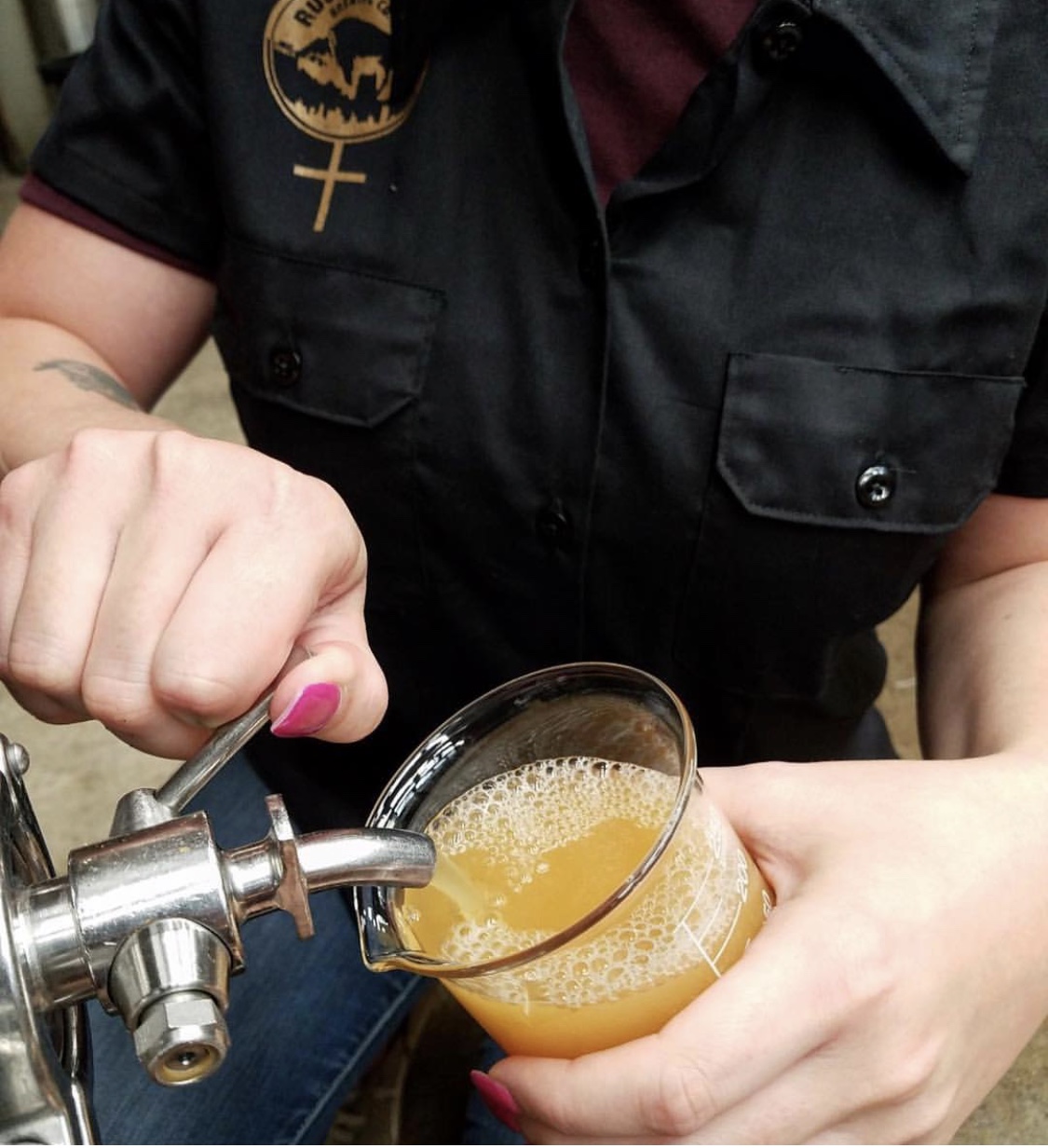 Photo by Rusty Nickel Brewing Co. Brewer pouring beaker of beer